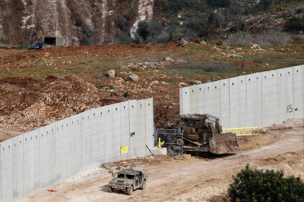 Israeli military vehicles cross a cement barrier on the border between Israel and the southern Lebanese village of Dhayra on Monday. Photo: AFP