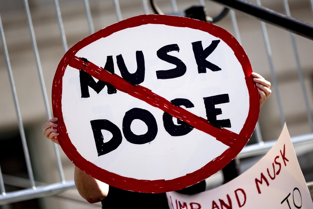 A demonstrator holds a poster displaying a prohibited traffic sign reading “Musk DOGE” during a rally to protest President Trump’s policies on February 17, 2025, in Los Angeles. Photo: AP