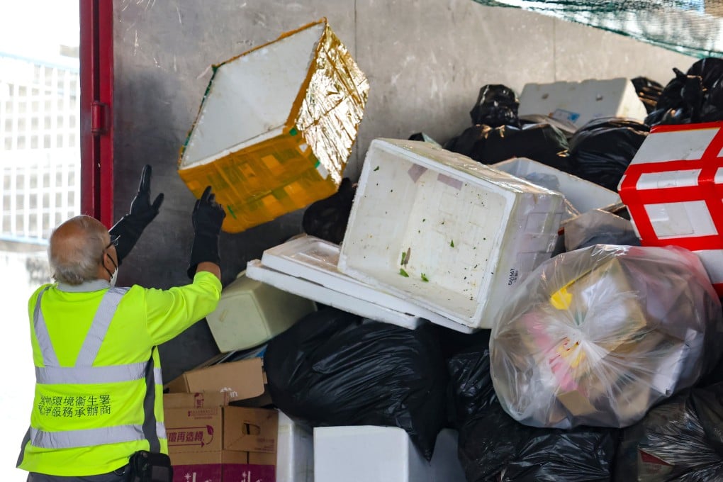 A cleaner outsourced by the Food and Environmental Hygiene Department to work on a refuse collection vehicle at Haiphong Road in Tsim Sha Tsui. Photo: Jelly Tse