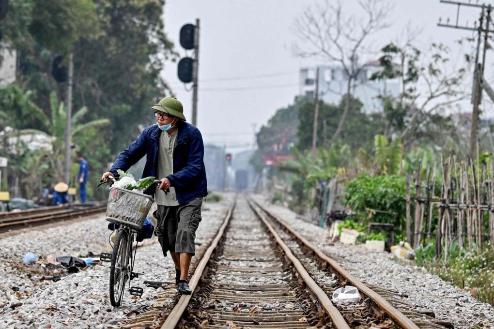 A Vietnamese man walks with his bicycle along a railway track in Hanoi last week. Photo: AFP