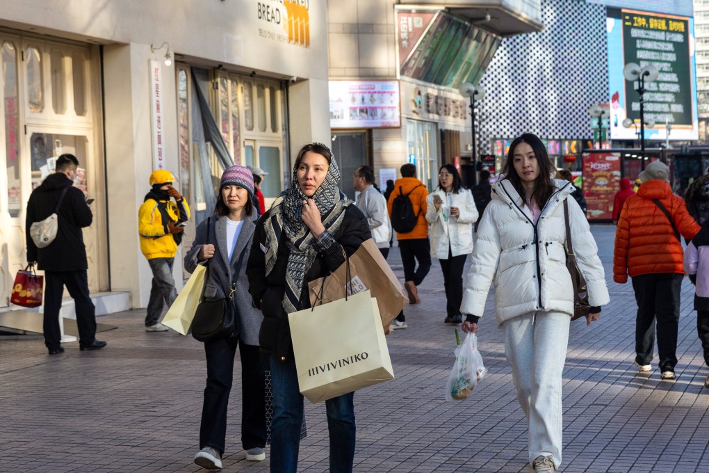 Shoppers walk along a street in central Beijing. China is stepping up efforts to arrest a slowdown in consumer spending. Photo: EPA-EFE