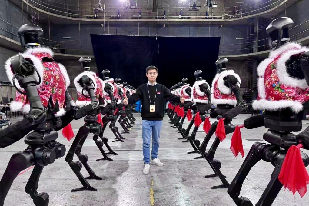 Wang Xingxing, CEO of Unitree Robotics, posing with the company’s humanoid robots. Photo: Weibo