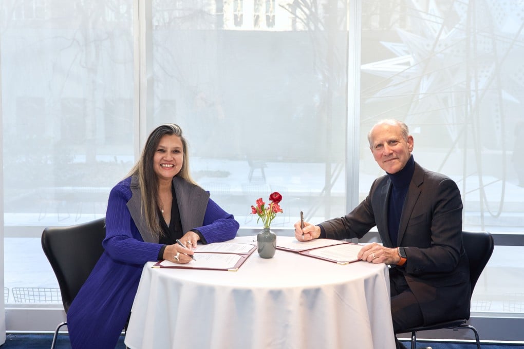 M+ director Suhanya Raffel signs the agreement with her MoMA counterpart, Glenn Lowry. Photo: Handout