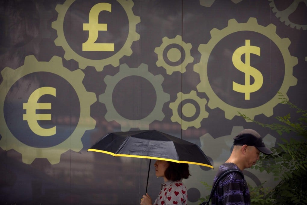 People walk past a mural displaying world currency symbols outside a bank in Beijing on July 20, 2018. Photo: AP