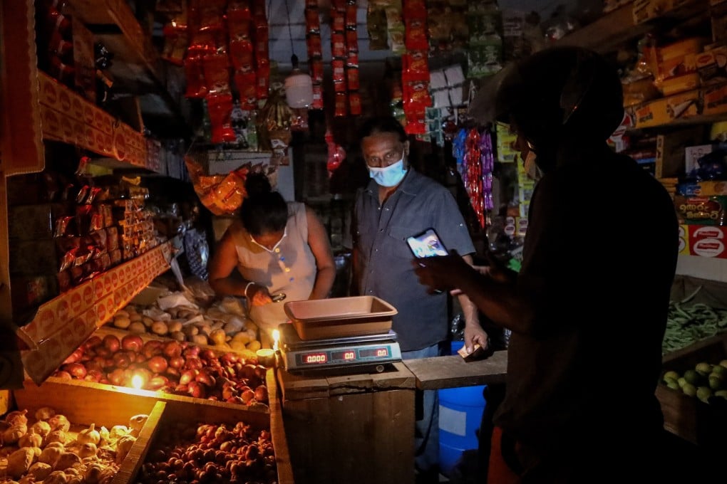 A grocery vendor illuminates his shop with candlelight amid power cuts in Colombo, Sri Lanka. Photo: EPA-EFE