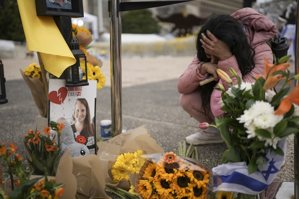 A woman mourns at a memorial for dead hostages Shiri Bibas, her two children, Ariel and Kfir and Oded Lifshitz in Tel Aviv, Israel. Photo: AP