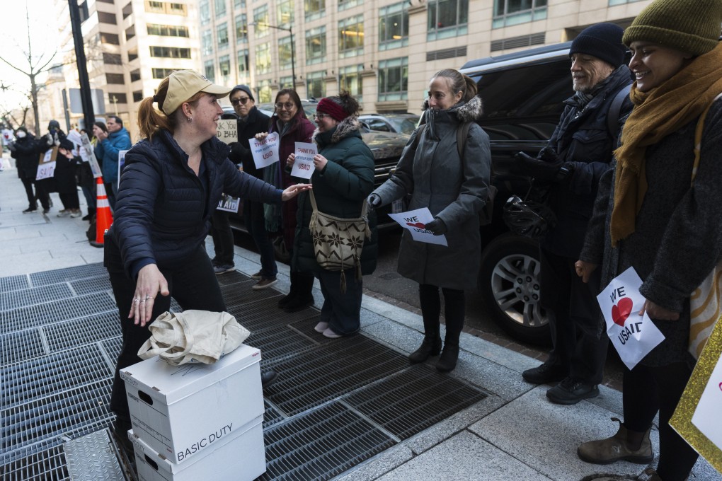 A USAID worker puts her personal belongings down to greet supporters outside the USAID’s Bureau of Humanitarian Affairs office in Washington on Friday. On Sunday, the US government said it is eliminating 2,000 USAID posts. Photo: AP