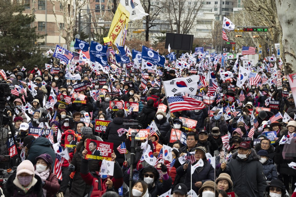Supporters of South Korean President Yoon Suk-yeol shout slogans and hold flags and placards reading “People are watching” and “Impeachment nullity” during a rally near the Constitutional Court in Seoul on Tuesday. Photo: EPA-EFE