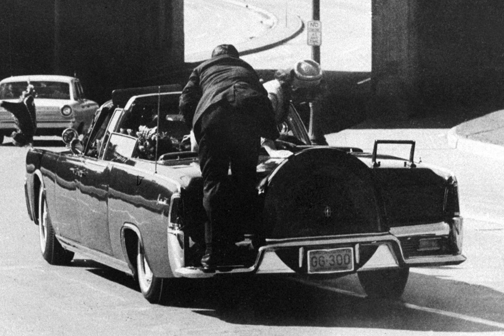 Secret Service Agent Clint Hill pushes Jacqueline Kennedy back in her seat as he attends to President John F Kennedy. Photo: AP
