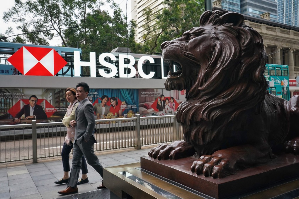 Pedestrians walk past a lion statue outside HSBC’s Hong Kong headquarters. Photo: Elson Li