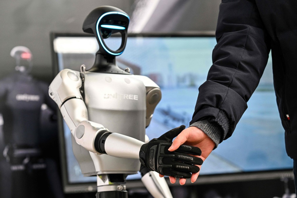 A man shakes hands with a humanoid robot from Unitree Robotics during the Global Developer Conference in Shanghai on February 21. Photo: AFP