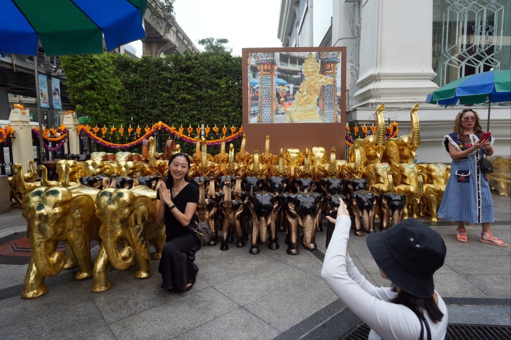 Tourists pose for photos at Erawan Shrine at Bangkok, Thailand. Photo: Sam Tsang