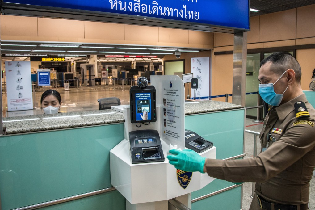 Immigration officers cleaning a fingerprint scanner at Don Muang International Airport in 2021. Photo: Getty Images
