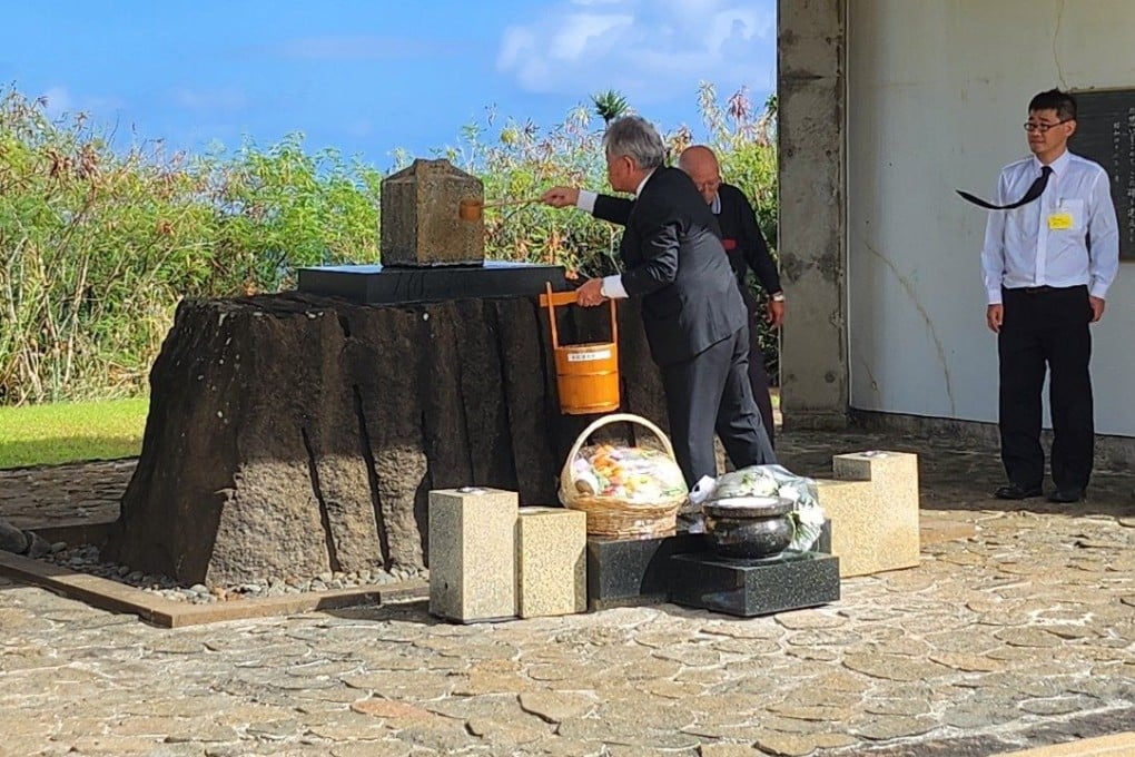 A member of the Iwo Jima Return Promotion Council carries out the ritual cleaning of a family tombstone on Iwo Jima. Photo: Kenji Aso, chairman of the Iwo Jima Return Promotion Council
