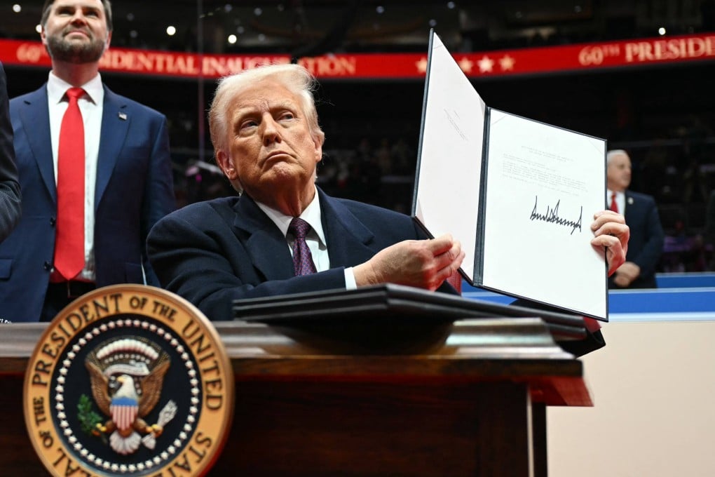 Donald Trump holds up a letter to the UN stating the US’ intent to withdraw from the Paris Agreement during his inaugural parade in Washington on January 20. Photo: AFP
