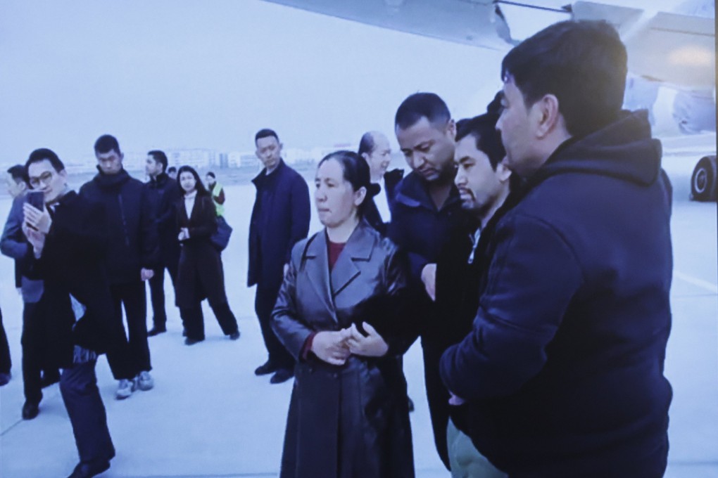 A screen displayed at a news conference in Bangkok on Thursday shows images of Uygur men arriving at an airport in China. Photo: EPA-EFE
