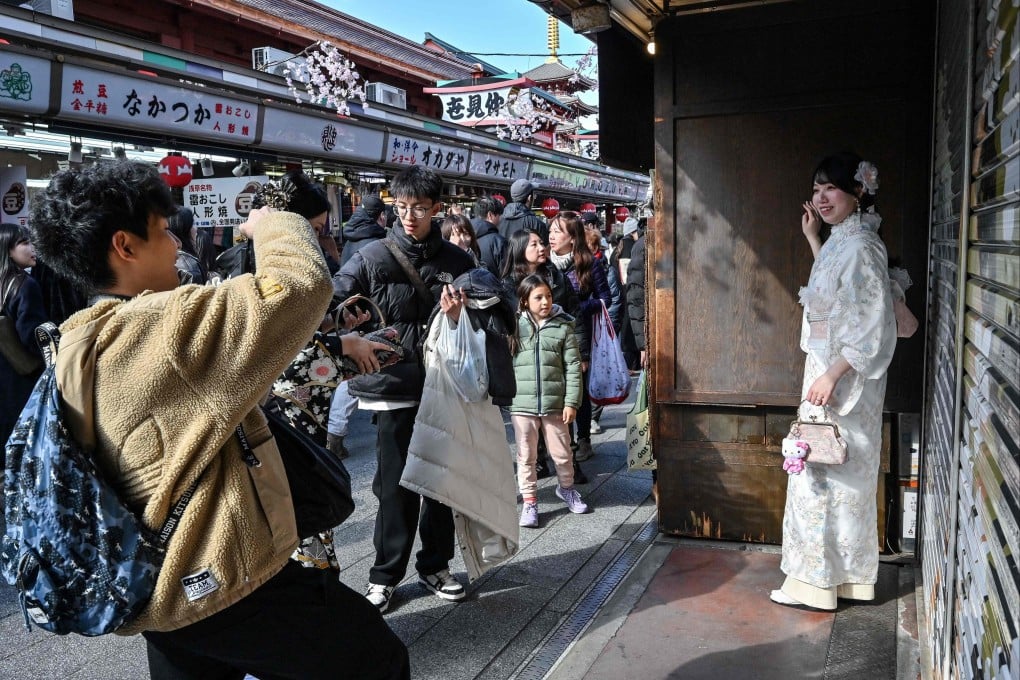A woman wearing a kimono poses for photos in the popular tourist destination of Asakusa, Tokyo, on February 21. Photo: AFP