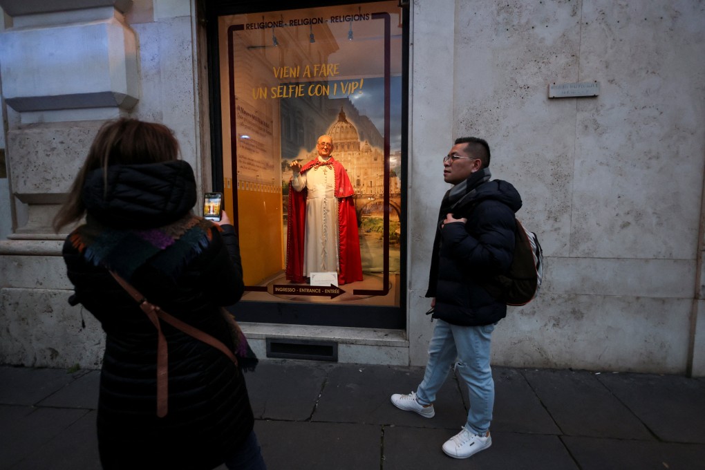 A woman takes a picture of a wax statue of Pope Francis, as he continues his hospitalisation, in Rome, Italy on Sunday. Photo: Reuters
