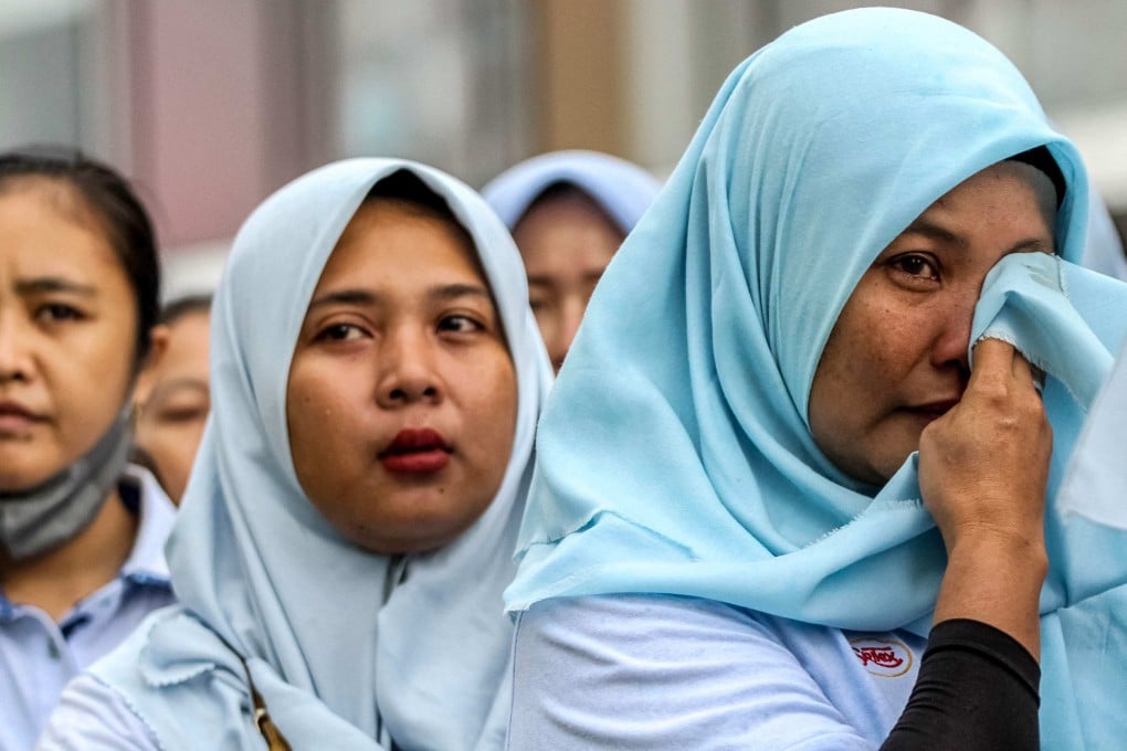 A former Sritex textile factory worker weeps as she listens to a farewell speech on Friday in Sukoharjo, Central Java. Photo: AFP