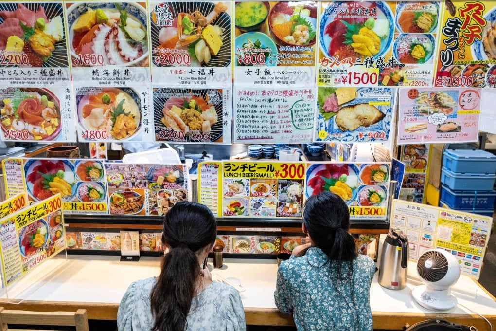 Two women sit in a restaurant at the Tsukiji fish market in Tokyo. Photo: AFP