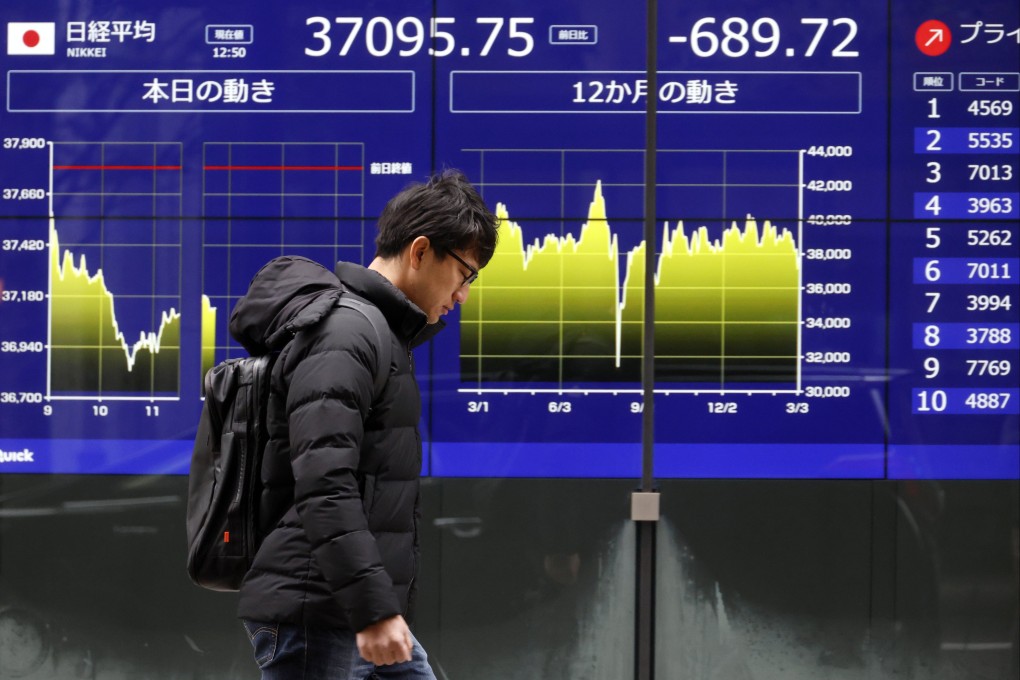 A passer-by walks past a stock market indicator board in Tokyo, Japan, on Tuesday. Photo: EPA-EFE