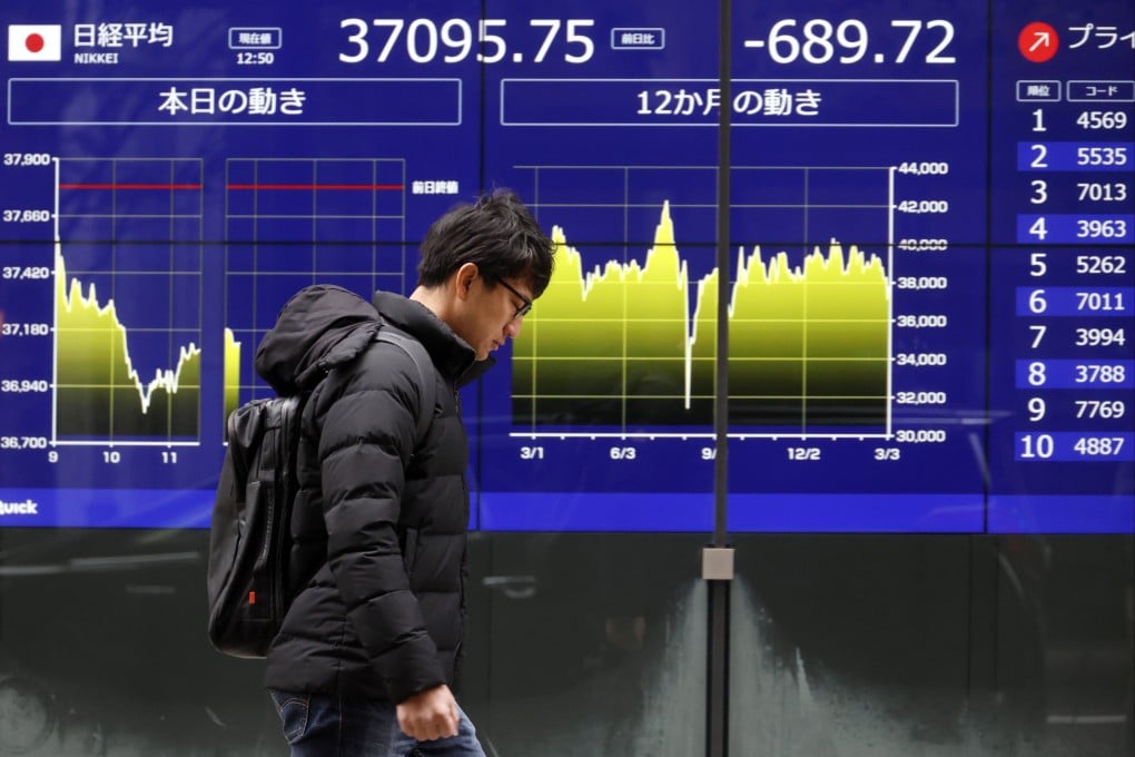A passer-by walks past a stock market indicator board in Tokyo, Japan, on Tuesday. Photo: EPA-EFE