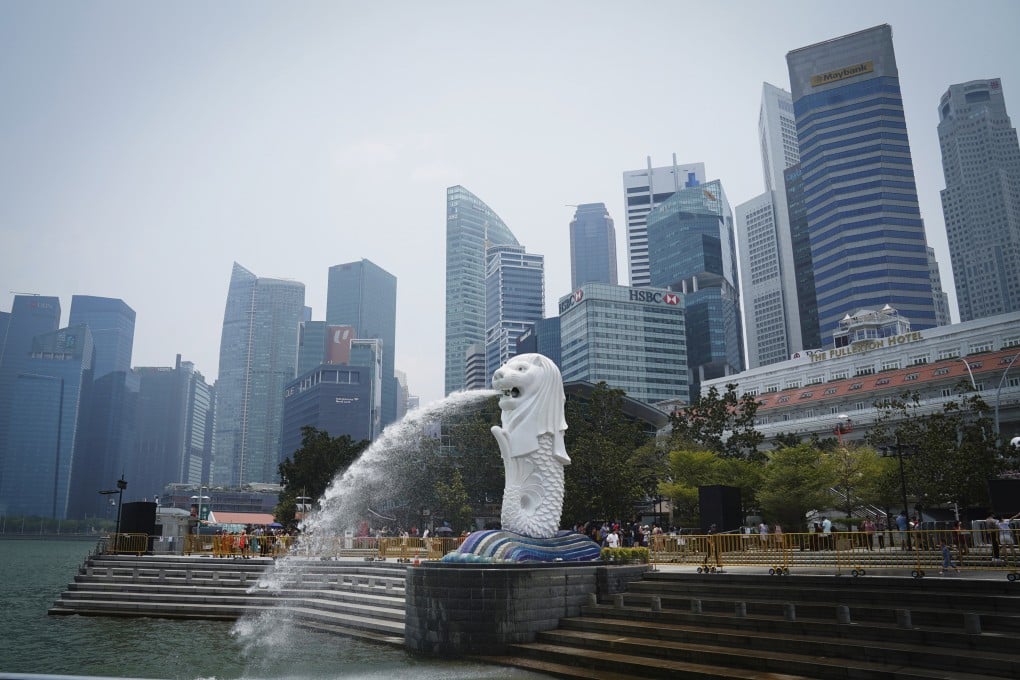 The Merlion statue spouts water at a park with the background of a business district in Singapore. Photo: AP