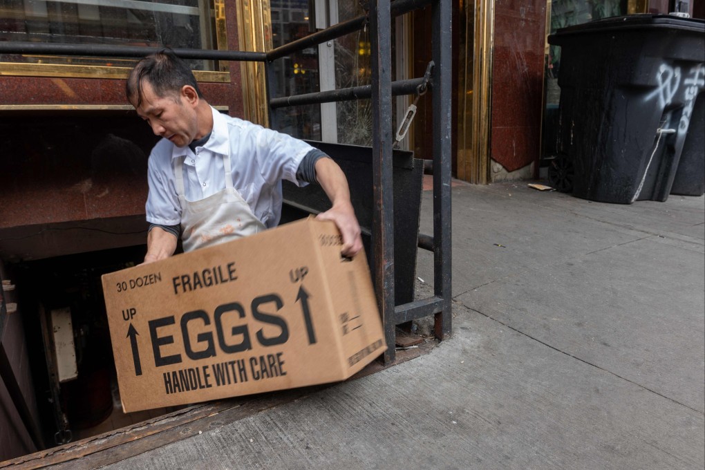A restaurant worker moves a box of eggs in Chinatown in New York on February 25. Amid an avian flu outbreak, the wholesale price of eggs is beginning to affect household budgets. Photo:  AFP