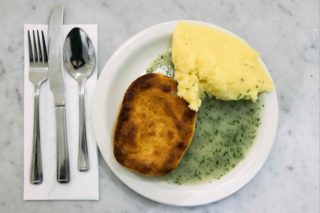 A plate of traditional pie and mash with liquor – parsley sauce – at G Kelly in Bow, East London. A campaign to get pie and mash special protected status is gaining ground in the UK. Photo: AFP