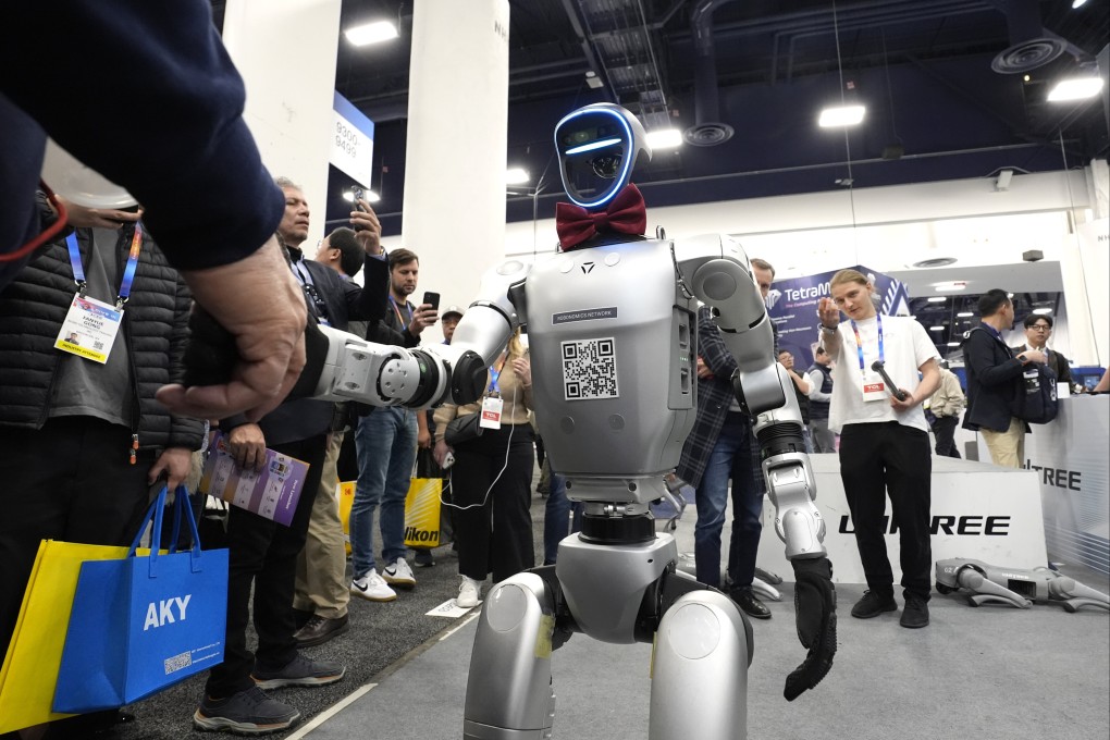 A humanoid robot from Unitree shakes the hand of an attendee at January’s CES trade show in Las Vegas. Photo: AP