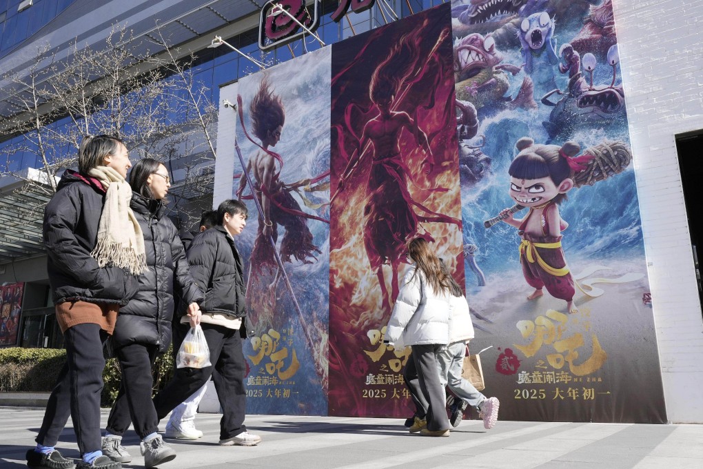 People walk by an advert in Beijing for the animated blockbuster Ne Zha 2 on February 20. Photo: Kyodo