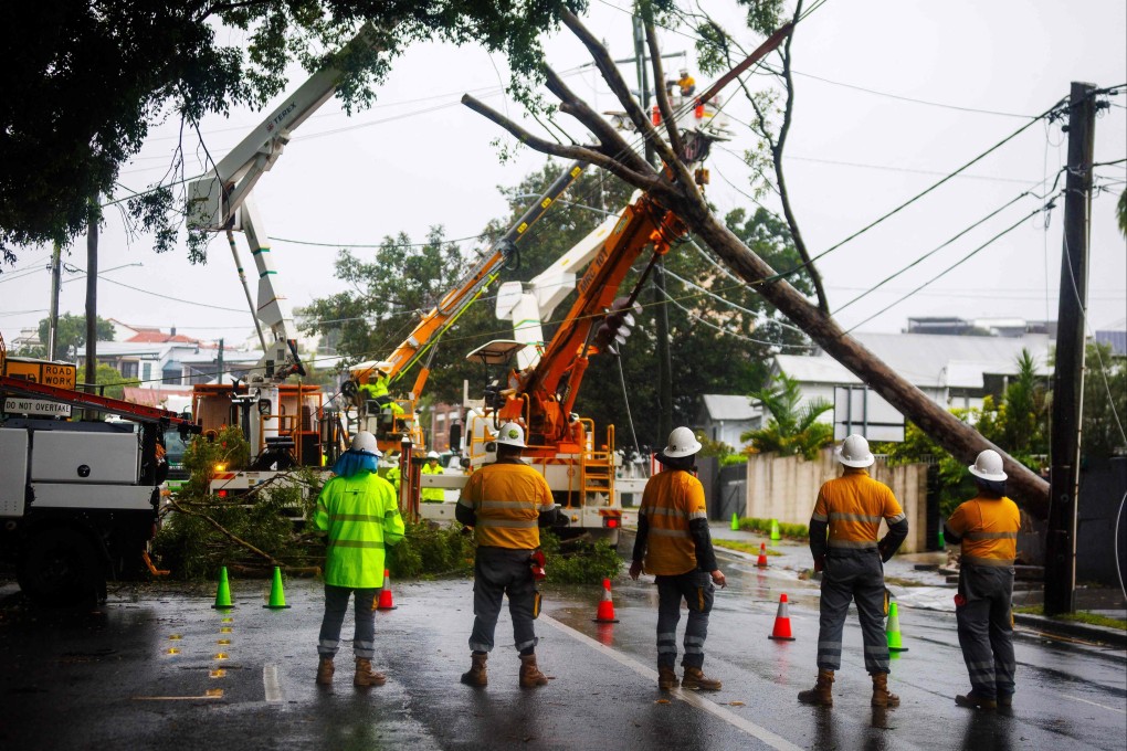 Energex crews clear a fallen tree following the passage of tropical cyclone Alfred in Brisbane on Saturday. Photo: AFP