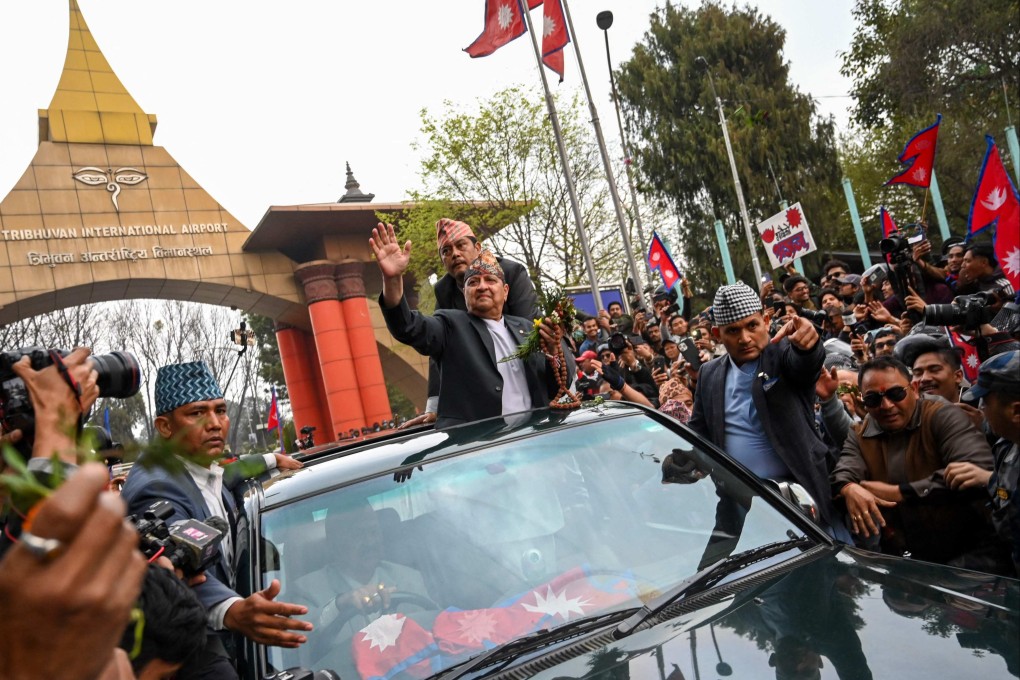Nepal’s former King Gyanendra Shah waves as he arrives at Tribhuwan International Airport in Kathmandu on Sunday. Photo: AFP