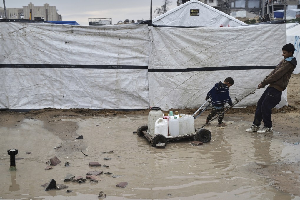 A boy and a child move water in plastic jerrycans in the Zeitoun neighbourhood of Gaza City. Photo: AP