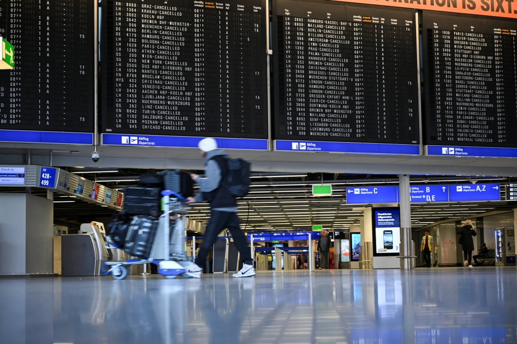 A passenger walks past boards displaying information on cancelled flights at the Frankfurt Airport. Photo: Reuters