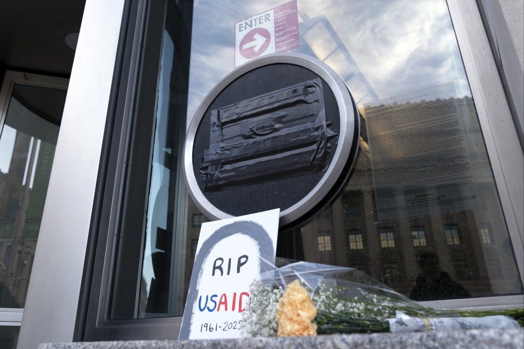 Flowers and a sign are placed outside the USAID headquarters on February 7, in Washington. Photo: AP