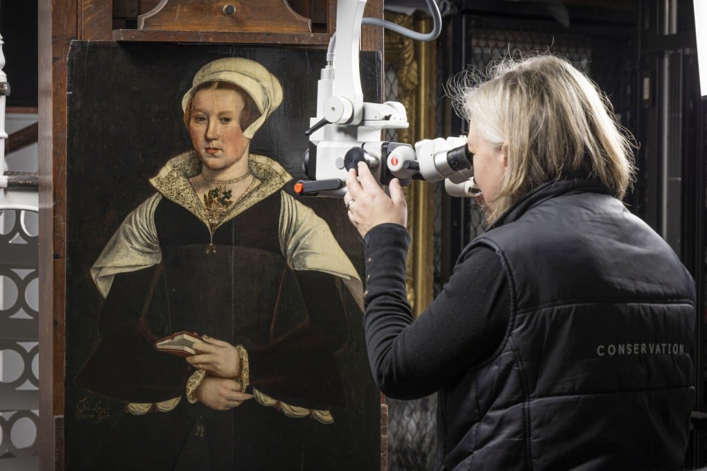English Heritage conservator Rachel Turnbull gives a portrait believed to be of Lady Jane Grey a final examination before it goes on display. Photo: English Heritage via AP
