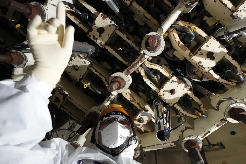 A Tepco employee inspects the No 5 reactor at the Fukushima Daiichi power plant last month. Photo: AP