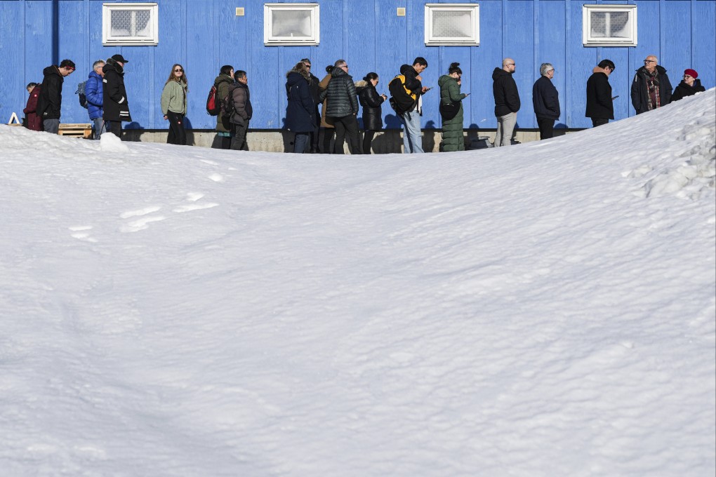 People stand in line outside a polling station to cast their vote in parliamentary elections, in Nuuk, Greenland, Tuesday, March 11, 2025. (AP Photo/Evgeniy Maloletka)