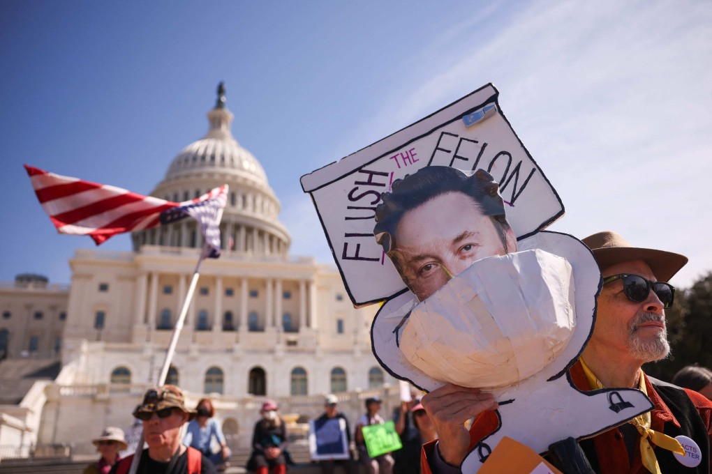 Protesters hold an upside-down American flag and a sign with Elon Musk’s face in a toilet during the “Shut Down the Coup” protest on the West Lawn of the US Capitol on Monday. Photo: AFP