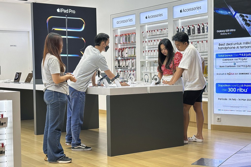 Customers inspect Apple iPhones at a shopping centre in Bali in February. Indonesia has secured a US$300 million investment from Apple, reopening the door for iPhone 16 sales in the country. Photo: EPA-EFE