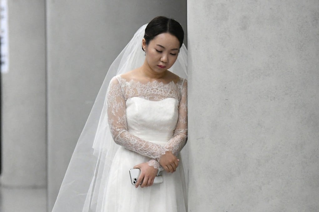 A bride leans on a pillar before a mass wedding ceremony organised by the Unification Church at Cheongshim Peace World Center in Gapyeong, South Korea, on February 7, 2020. A new study of young Koreans’ internet posts found that 67.1 percent of marriage-related posts reflected negative sentiment. Photo: AFP