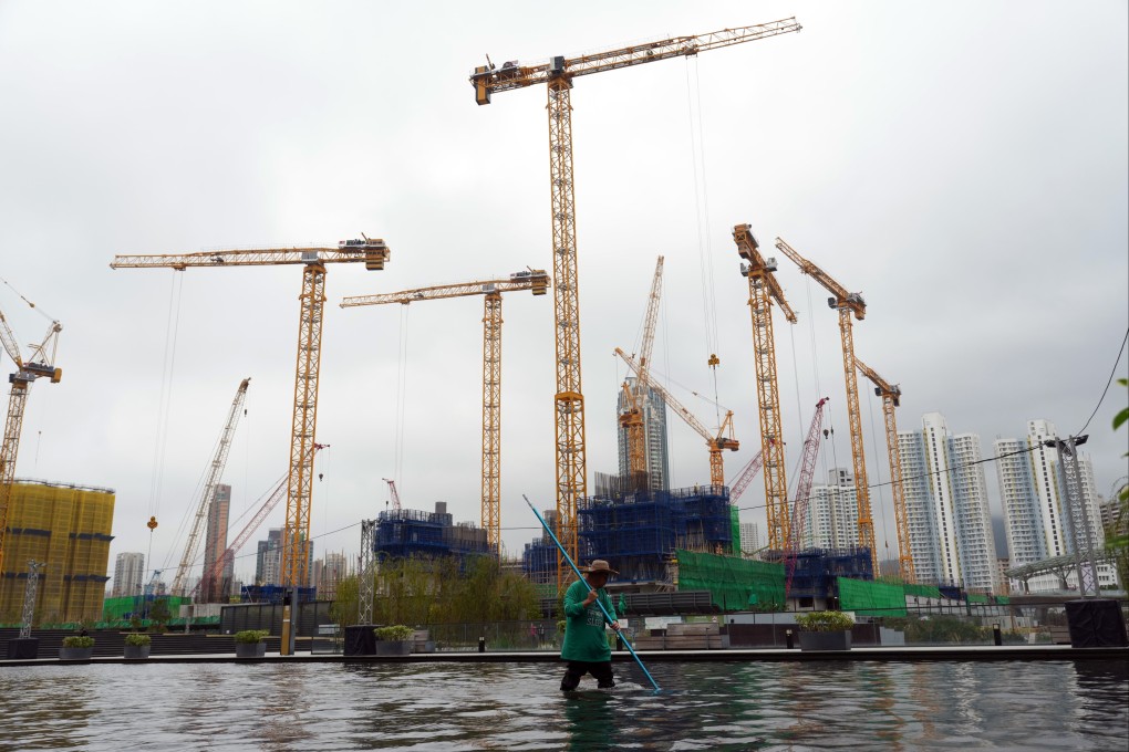 A worker cleans a pool near residential construction projects in the Kai Tak area of Hong Kong on March 11, 2025. Photo: May Tse