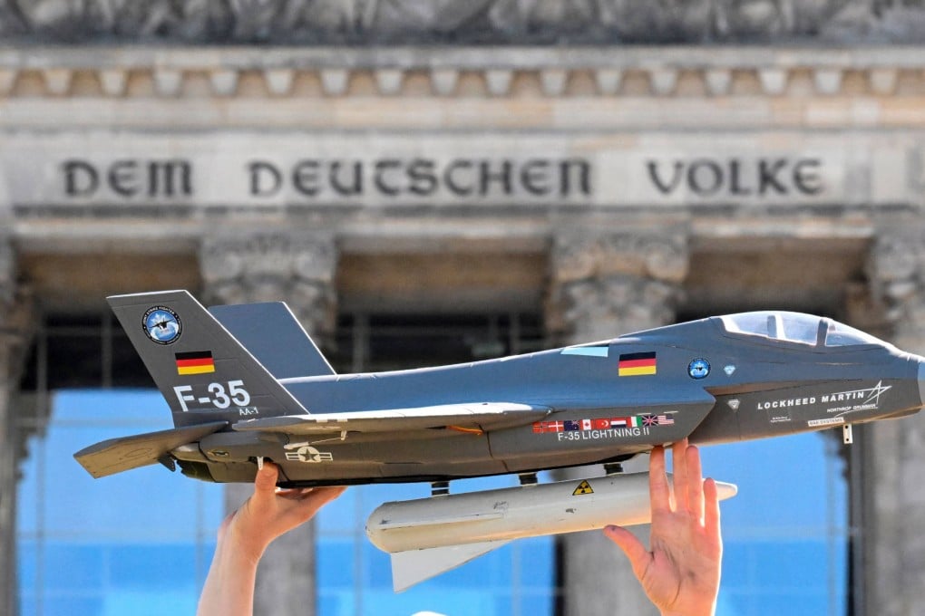 An activist holds a mock up of a Lockheed Martin F-35 Lightning II fighter plan during a protest in front of the Reichstag building that houses the Bundestag in Berlin in 2022. Photo: AFP