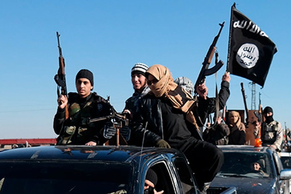 Militants riding in a convoy wave an Isis flag. Photo: AP