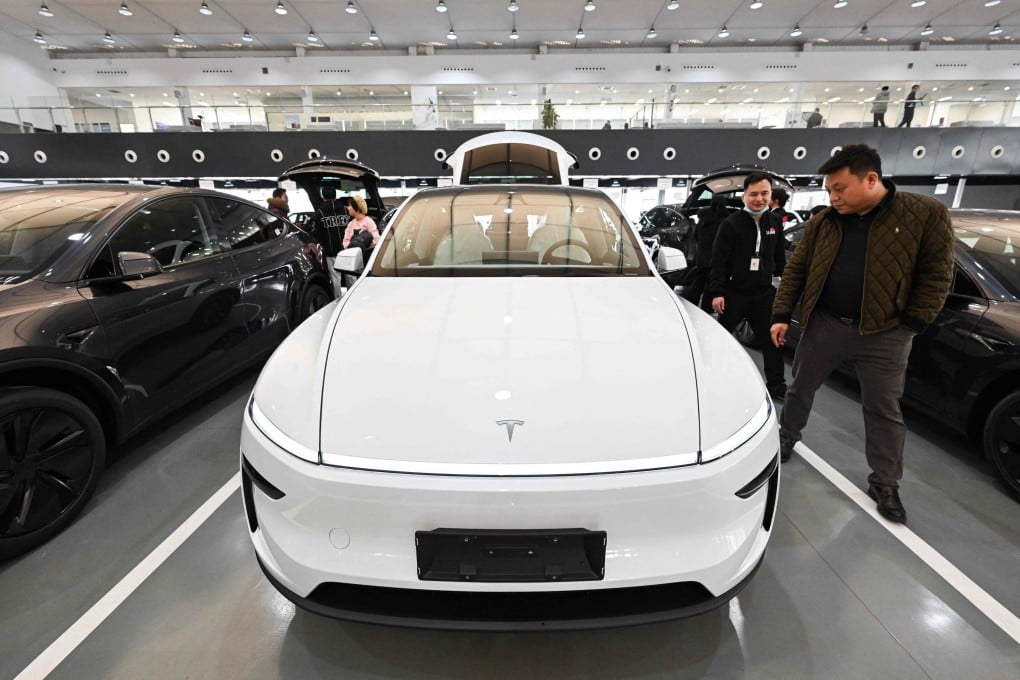 People check out a Tesla electric car at the companys delivery centre in Beijing on February 27, 2025. Photo: AFP