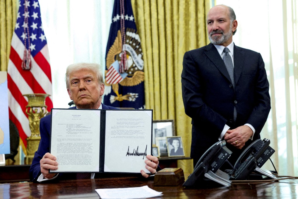 US President Donald Trump holds an executive order about tariffs increase, flanked by U.S. Commerce Secretary Howard Lutnick, in the Oval Office of the White House in Washington on February 13. Photo: Reuters