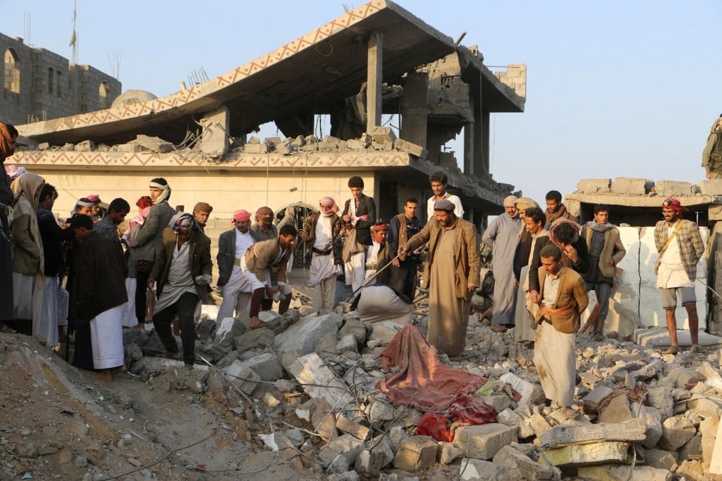 People gather on Sunday by the rubble of a house in Yemen hit by a US strike. Photo: Reuters