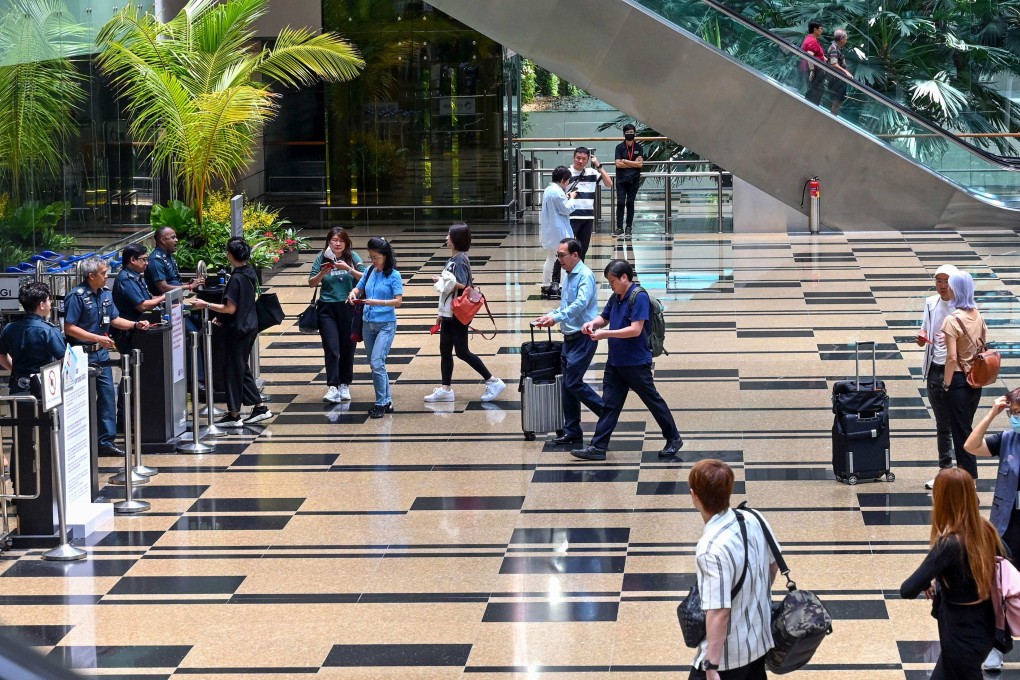 Passengers walk in the departure transit hall at Changi Airport in Singapore. Photo: AFP