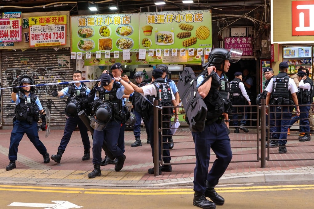 Officers equipped with shields and other protective gear were seen searching King Hing Building along Mong Kok’s Argyle Street on Monday noon. Photo: Jelly Tse